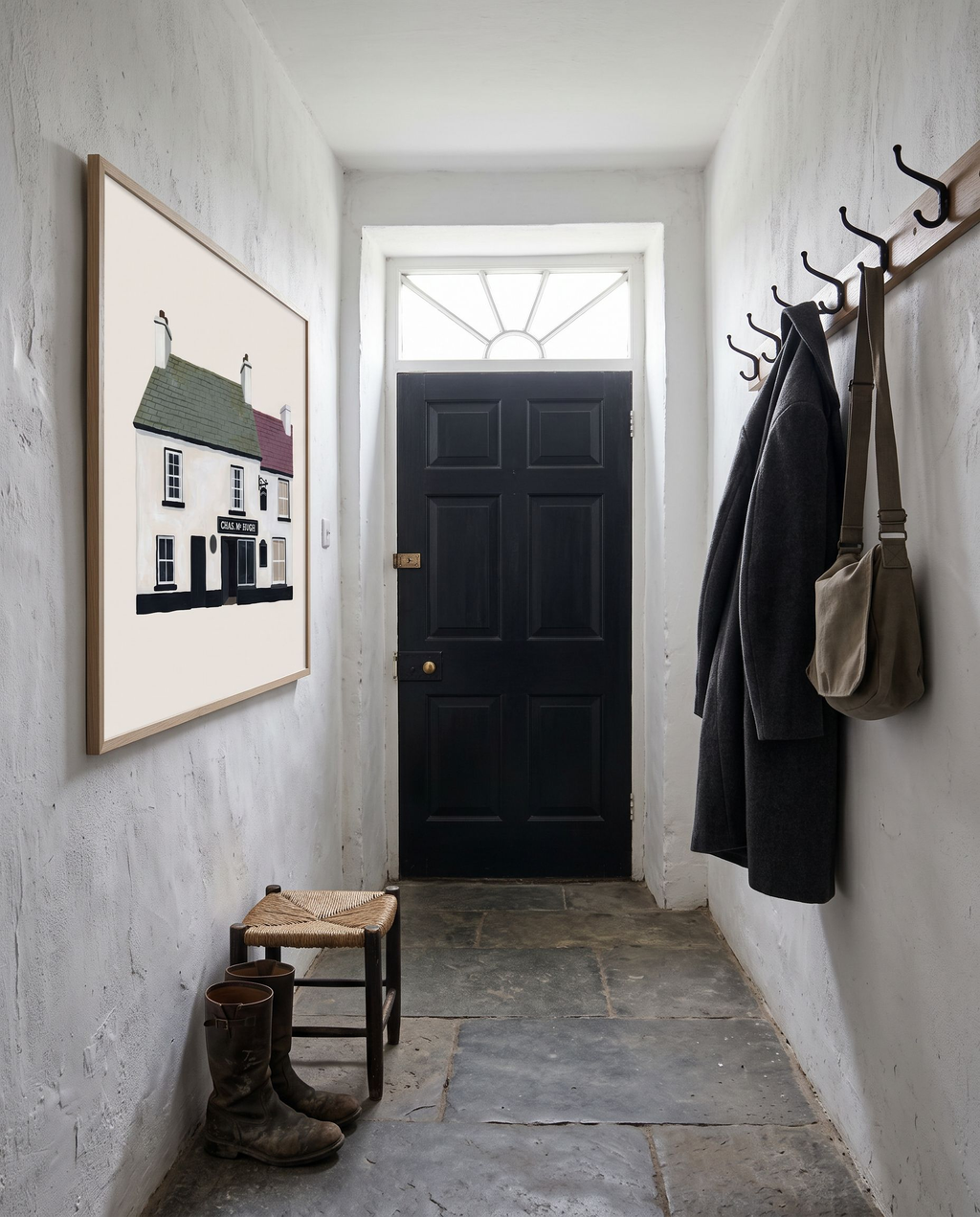Nancy's Ardara print framed in oak in a whitewashed hallway with slate flagstones, a black front door and a wool coat on a hook